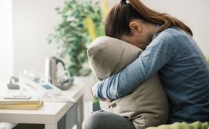 Sad woman with face in pillow