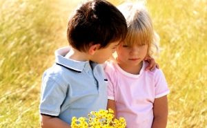 young boy comforting girl with flowers