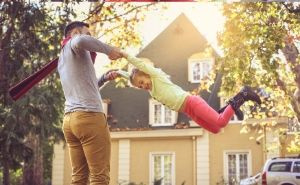 dad swinging daughter outside happy smiles