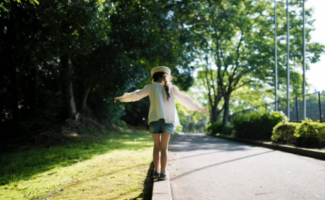 Young girl walking outside balancing
