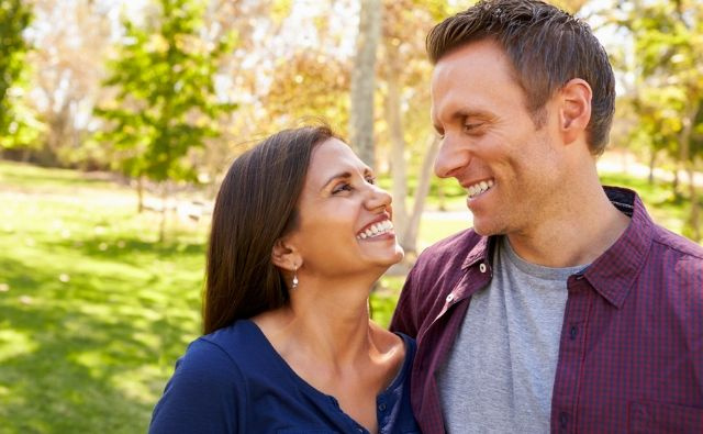 happy couple outside smiling at each other