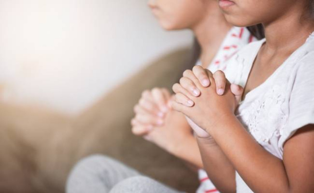 Children with hands folded prayer